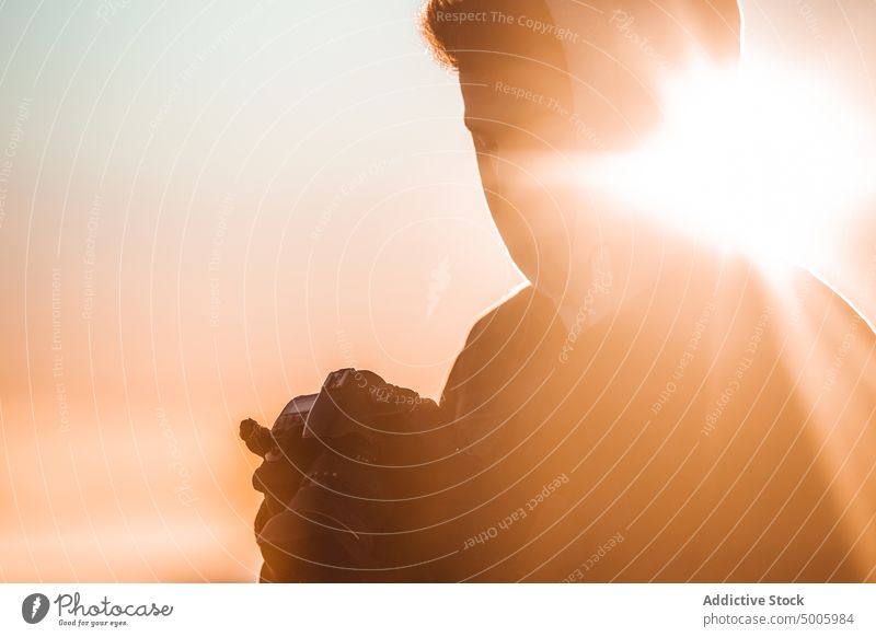 Silhouette of a man against the light looking at photos in his reflex camera silhouette photographer landscape person evening sky travel professional shot hobby