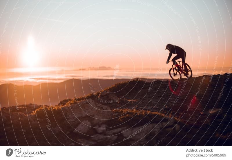 Man riding on bike on hill man helmet extreme sport mountain bicycle top guy sky sun sunshine male safety heaven adventure adrenaline mtb sunlight peak