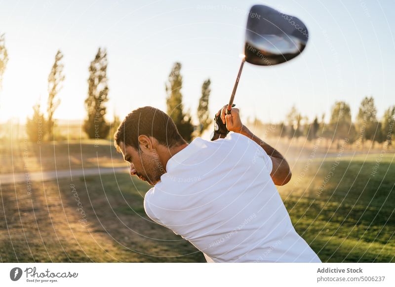 Golfer playing golf on course in countryside golfer sport prepare ball professional nature club man putter lean forward player field club and ball greenery