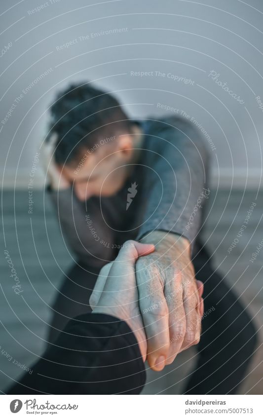 Unrecognizable man with problems receiving help from woman holding her hand unrecognizable faceless desperate guy mental disorder helping hand head sitting