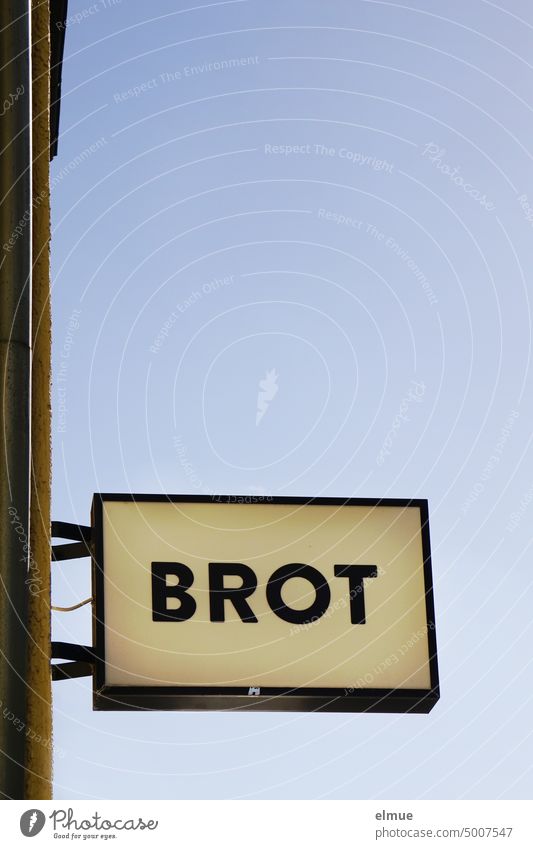 Light box with the inscription BREAD on a house wall Lightbox Bread Billboard Neon sign Illuminated advertising Bread sale staple food Grain price