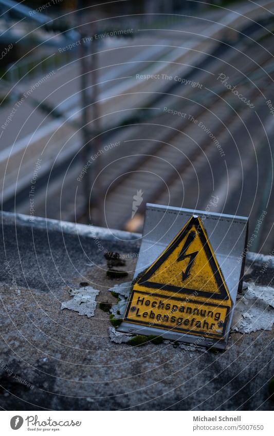 Warning sign over railroad tracks high voltage High voltage power line pylon Power lines Energy Danger of Life dangerous to life Electricity Electricity pylon