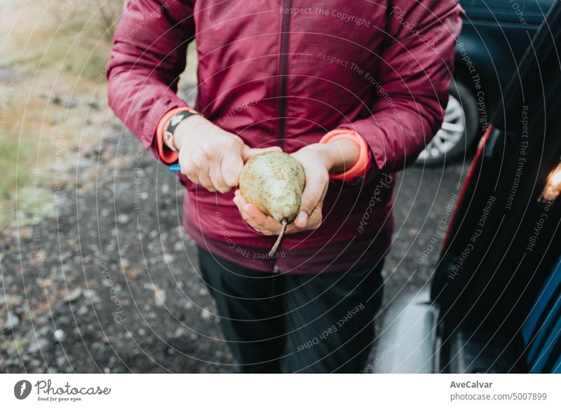 Unrecognizable woman cooking in camping gas during a rainy day.Vanlife lifestyle for urban travellers. cinematic scandinavian landscape. Travel on epic road trip through mountains.