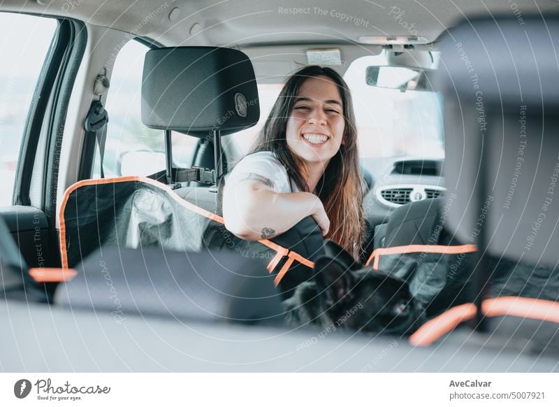 Smiling Young Woman to camera before taking her french bulldog for a walk on the car. Affectionate Pet French Bulldog.cute lovely moment of dog lover owner pet