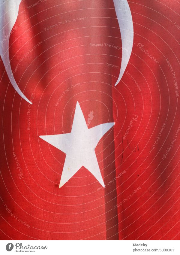 Red Turkish flag with white star in summer sunshine at a house entrance in Inkumu on the Black Sea in Bartin province, Turkey Flag Stars White bright red Cloth