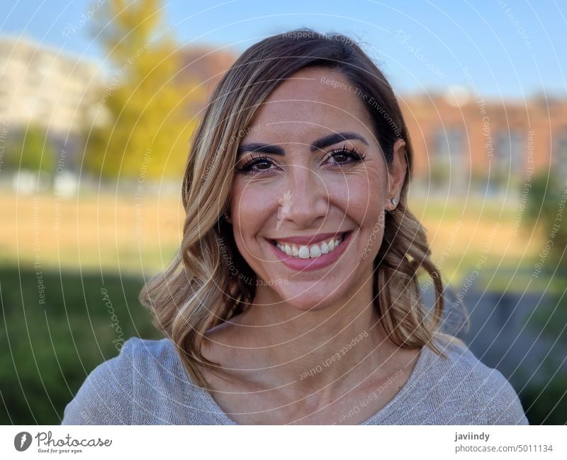 Portrait of a happy middle-aged woman in an urban park. Attractive female smiling to camera. middle age looking at camera face person girl portrait adult