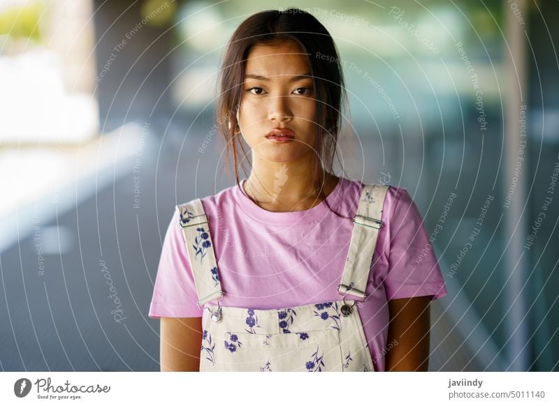 Young Chinese woman looking at camera with serious expression in a modern office building asian chinese japanese fashion person girl face female beauty young