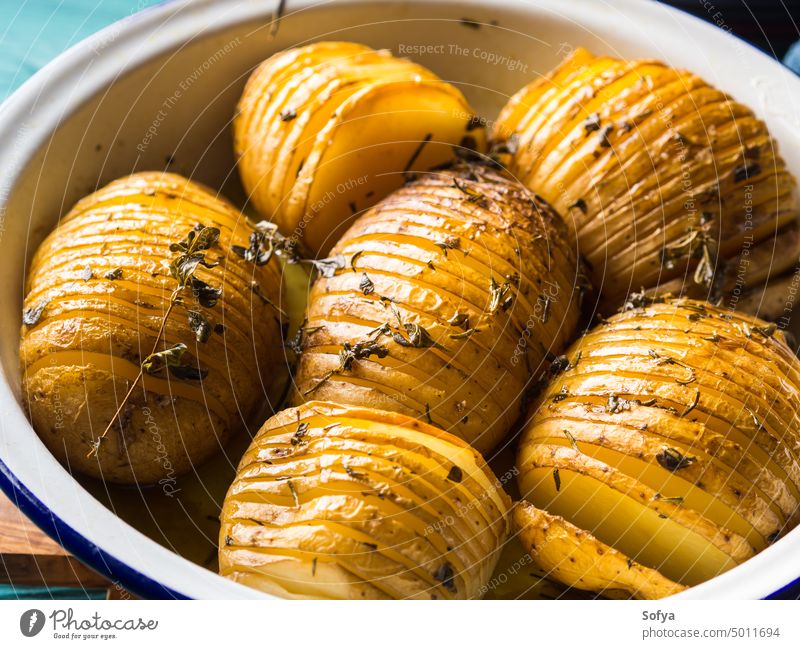 Baked potatoes cooked with herbs bake vegetable food savory rosemary marjoram salt recipe wooden enamel tin oven kitchen homemade rustic slice chip snack