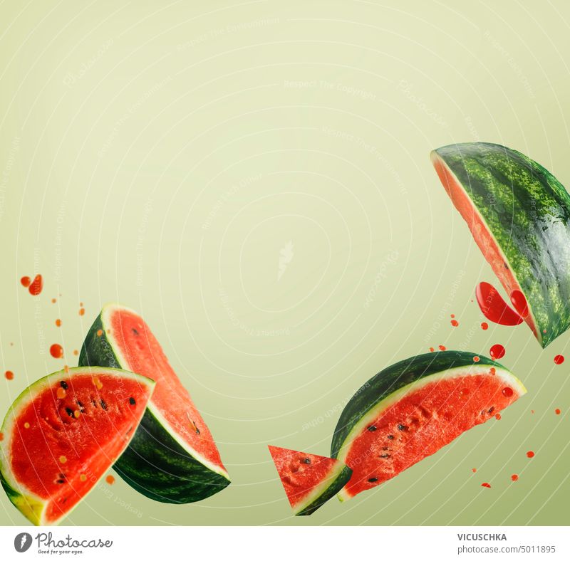 Flying watermelon slices with juice splash at light green background. Creative food levitation flying creative fruit design sweet object motion refreshment