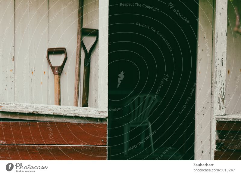 Garden tools, garden chair and mysterious view into a small wooden garden shed Gardenhouse Gardening equipment Chair Looking Scandinavian Norway Red