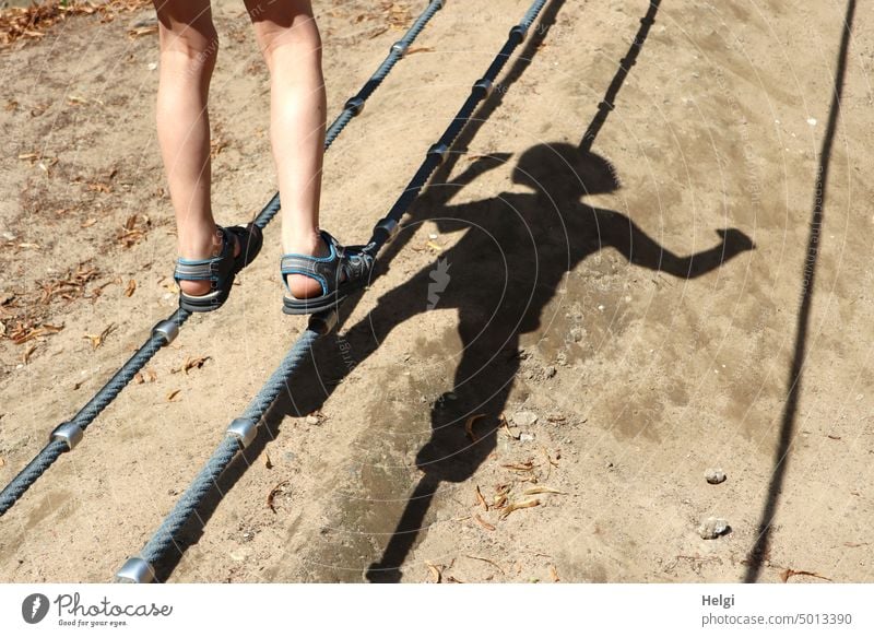 Boy balancing on playground equipment, only legs and a shadow of the body are visible Boy (child) Child Schoolchild Legs Shadow body shadow game device Rope