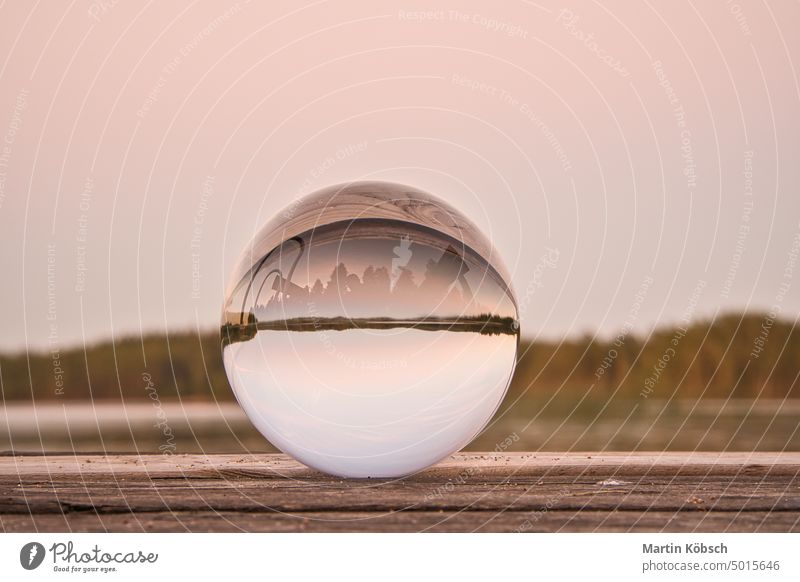 Glass ball on a wooden pier at a Swedish lake at evening hour. Nature Scandinavia Footbridge wooden footbridge glass ball sphere Sweden blue hour evening light