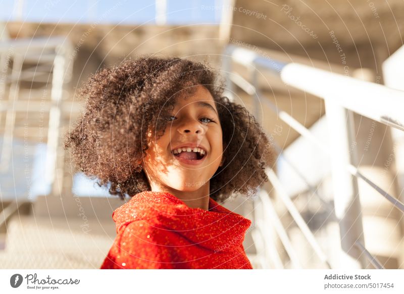 Smiling cute black girl on street sunshine smiling cheerful child step sunny day african american happy positive walk city town hairdo hairstyle female kid