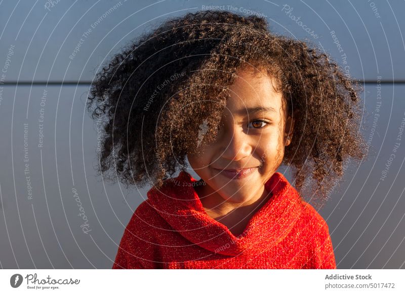 Smiling cute black girl on street sunshine smiling cheerful child step sunny day african american happy positive walk city town hairdo hairstyle female kid