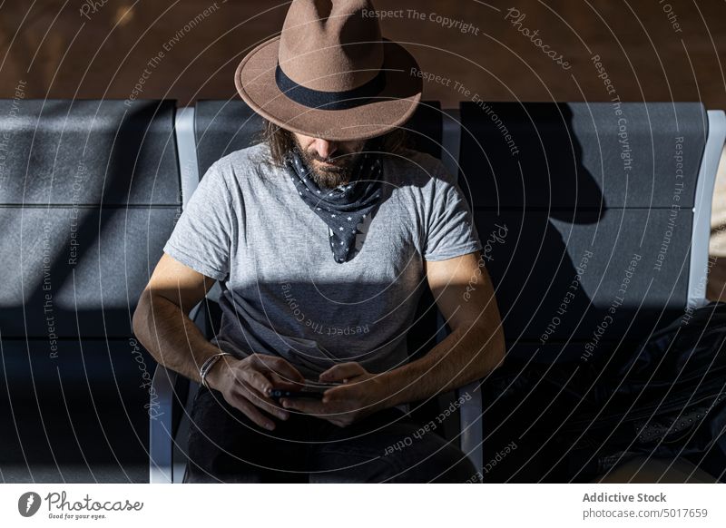 Man on a mobile phone at airport bench while waiting man transport smartphone travel flight terminal sleep using rest transportation flying passenger nap trip