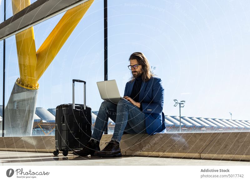 Busy man using laptop in airport lounge trendy style business trip busy work suitcase travel passenger device gadget connection internet wireless online