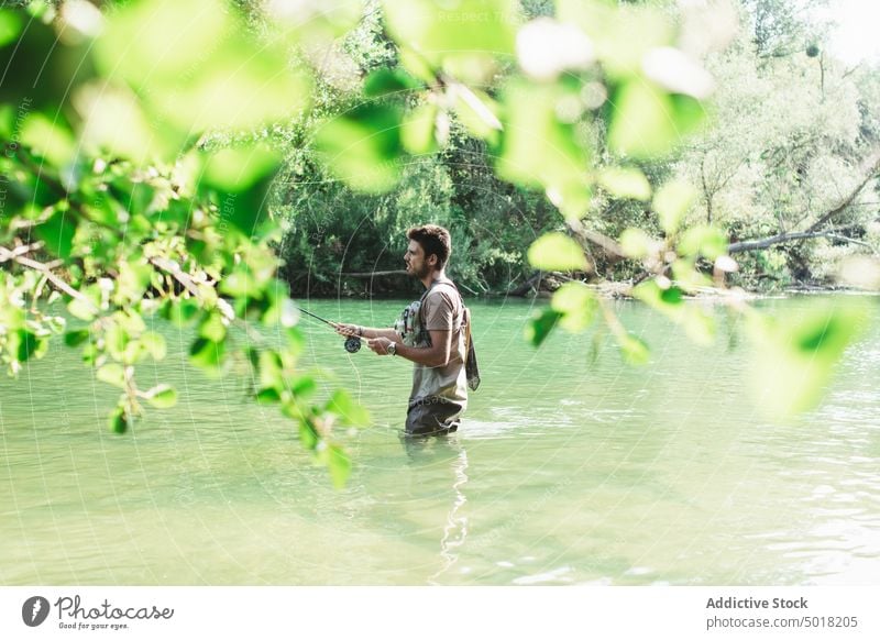 Fisherman man throwing fishing rod into a mountain river fisherman person water recreation sport activity nature catch summer fly hobby lifestyle action male