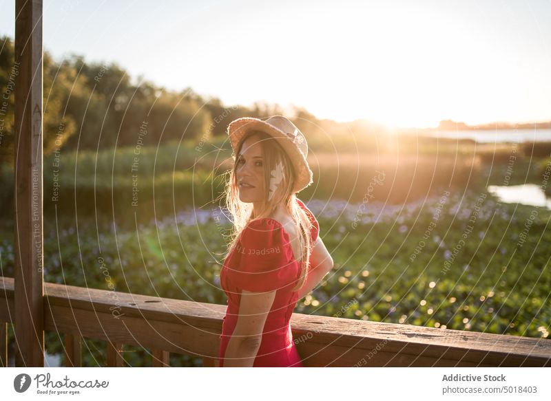 Woman admiring nature from veranda in evening traveler contemplate lagoon vacation trip terrace sky woman city feminine shadow admire landscape idyllic shiny