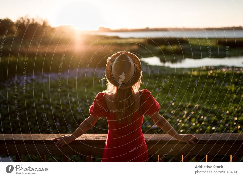 Faceless traveler admiring nature from veranda in evening contemplate lagoon vacation trip terrace sky woman city feminine shadow admire landscape idyllic