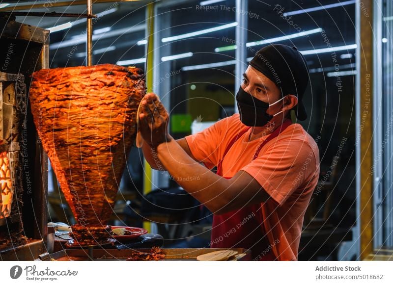 Mexican chef preparing tacos in restaurant kitchen prepare food beef work vertical broiler man meat cook process job dish tradition culture mexican mask