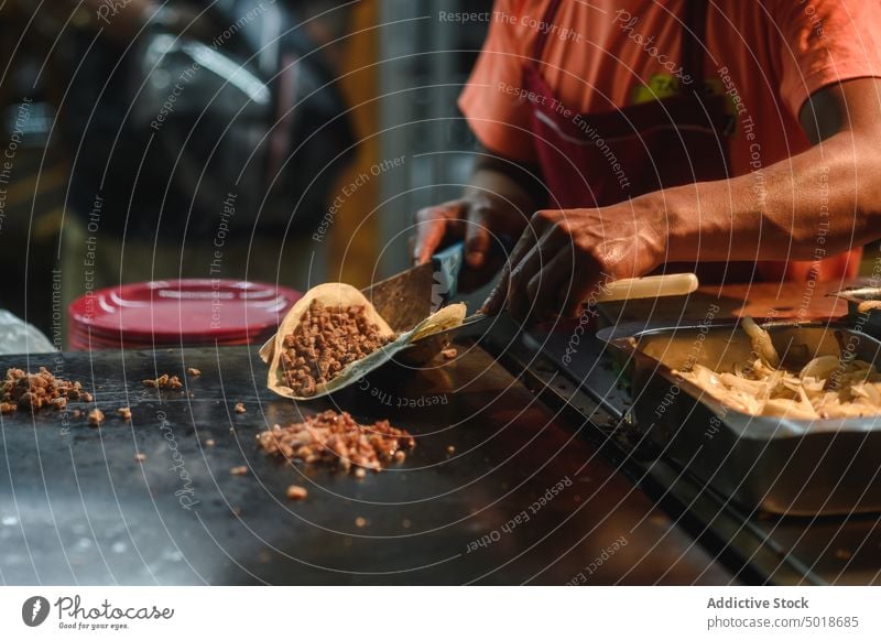 Crop ethnic chef preparing tasty tacos in restaurant kitchen prepare street food mexican food lunch dinner dish man product work cook ingredient beef meat