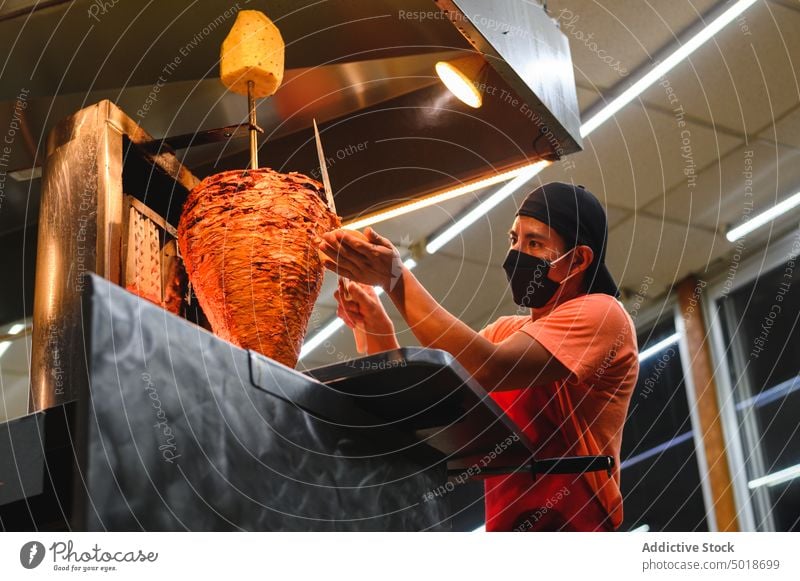 Mexican chef preparing tacos in restaurant kitchen prepare food beef work vertical broiler man meat cook process job dish tradition culture mexican mask