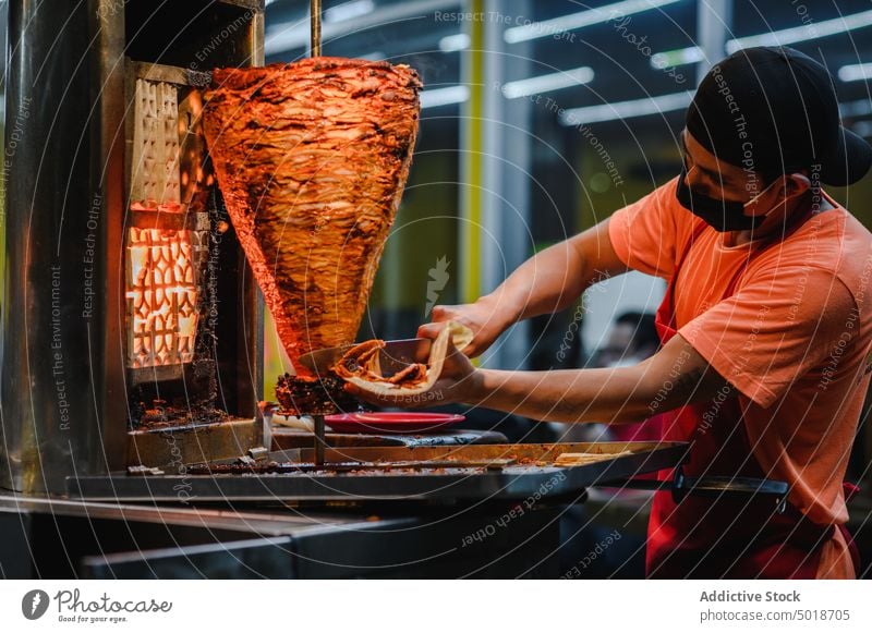 Mexican chef preparing tacos in restaurant kitchen prepare food beef work vertical broiler man meat cook process job dish tradition culture mexican mask