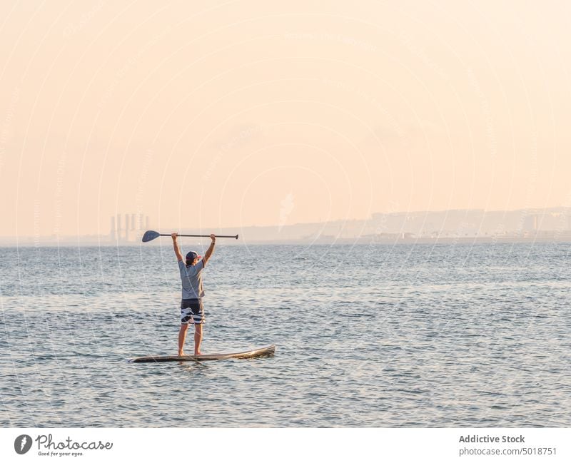 Man with paddle on surfboard on high seas man surfing ocean water active vacation summer male lifestyle extreme wave adventure recreation athlete summertime