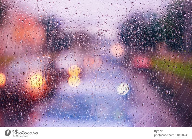 Water Drops Of Rain On Blue Glass Background. Street Bokeh Lights Out Of Focus. Autumn Abstract Backdrop vibrant glass colorful glow fall abstract purple