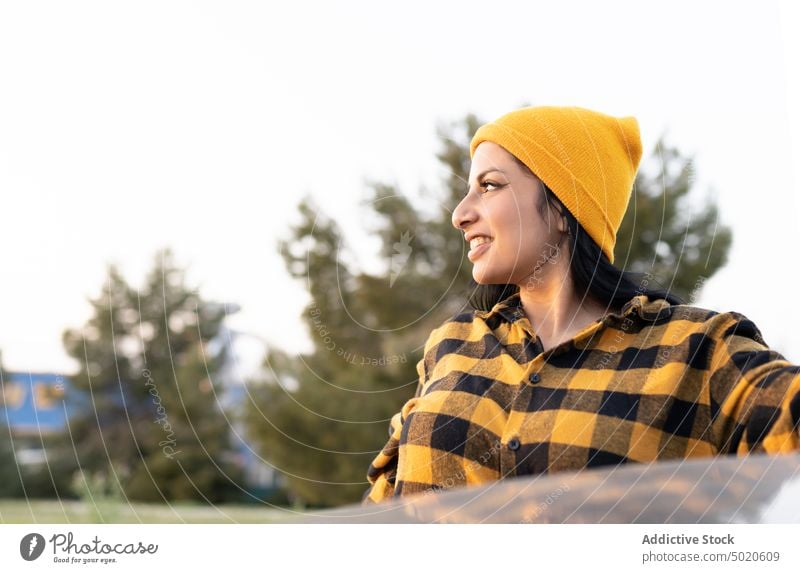 Confident young Latin American lady standing near car in nature and smiling woman smile happy road trip tourist countryside self assured confident style trendy