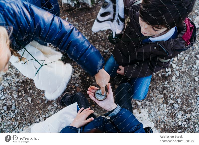 group of children holding a compass hand male young person nature tourism background explore view tourist cropped people white travel one blue landscape