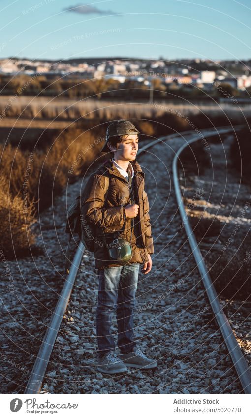 Kid hiking in the woods standing in a train track child kid discovery camping young excited one activity log caucasian lifestyle adventure nature fun boy