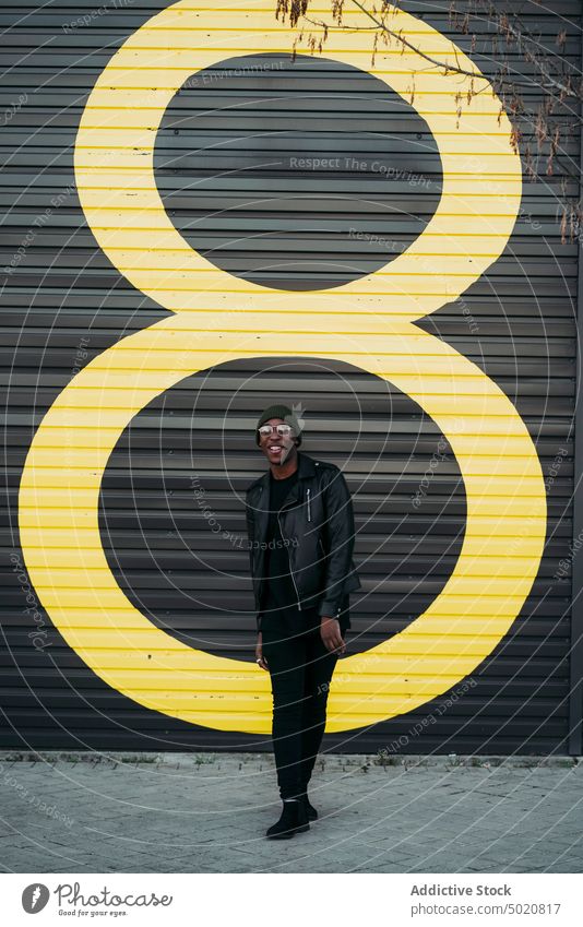 Young black man on city street style wall exterior fashion male modern contemporary shadow confident positive trendy casual guy african american ethnicity