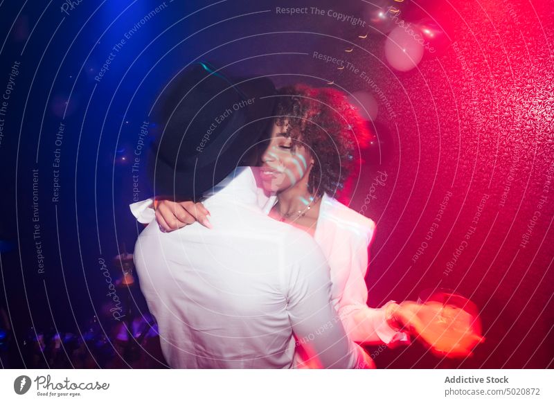 Ethnic couple dancing in nightclub dance party together fun colorful neon illuminate silhouette ethnic man woman love light dark modern music event glow evening