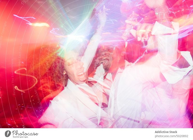 Black couple dancing under colorful light dance fun party nightclub scream ethnic illuminate neon man woman yell shout black african american nightlife bright