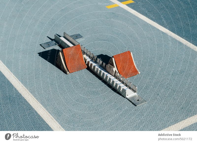 Starting blocks placed on racetrack starting blocks track and field stadium training sprint equipment rubber blue sport arena sunny daytime gear ready prepare