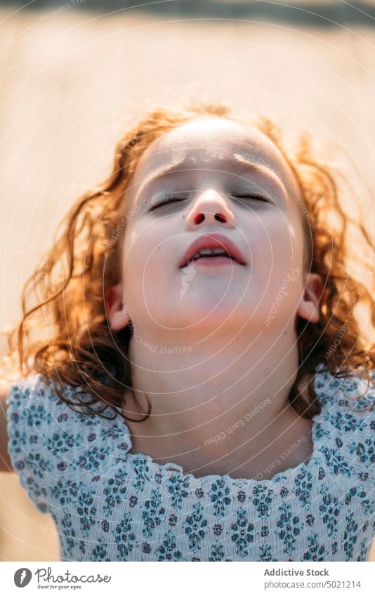 Girl with closed eyes kid ginger sunny daytime child little excited fun innocence carefree red curly hair cute adorable sweet lovely charming face expression