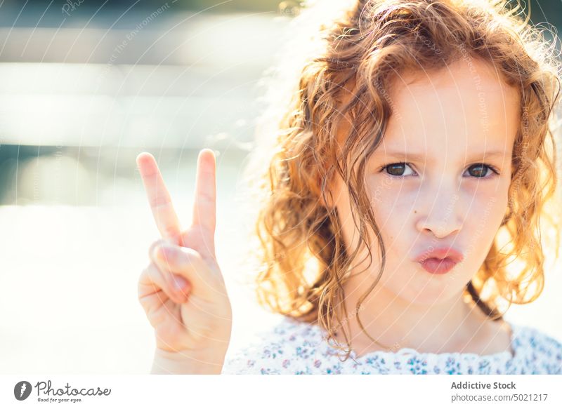 Girl looking at camera kid ginger sunny daytime child little excited fun innocence carefree red curly hair cute adorable sweet lovely charming face expression