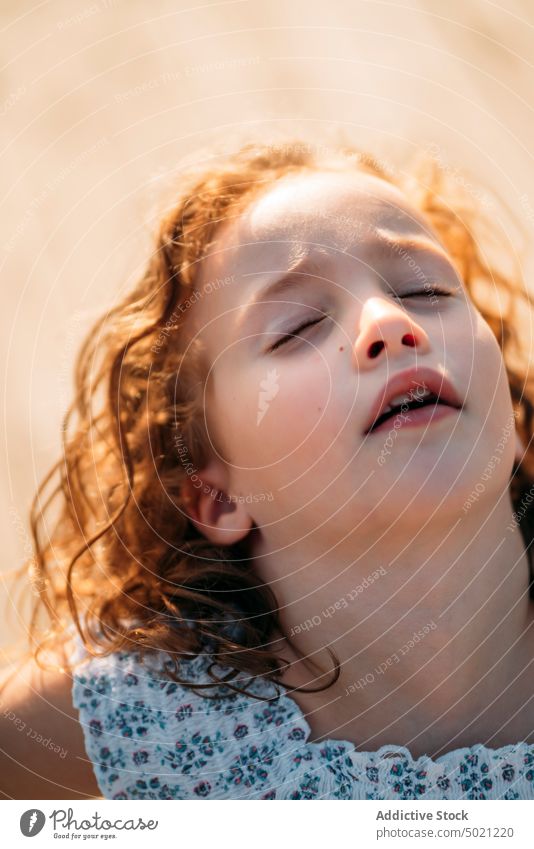 Girl with closed eyes kid ginger sunny daytime child little excited fun innocence carefree red curly hair cute adorable sweet lovely charming face expression