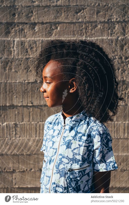 Smiling black girl looking away in wall schoolgirl cheerful happy street elementary lifestyle smart enjoyment smiling ethnic african american childhood activity