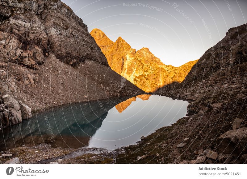 Mountain lake with mirrored surface mountain rock reflection landscape nature highland wild rough water range scenery ridge majestic magnificent rocky yellow