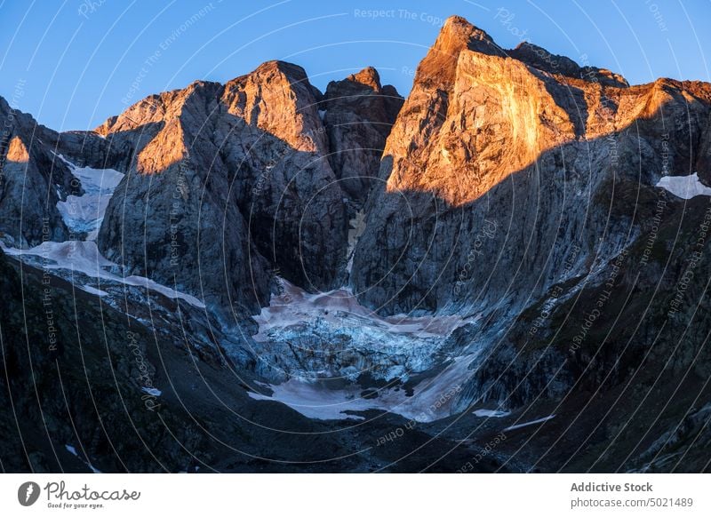 Snowy mountains lit by sunset light in evening snow highland sunlit landscape winter twilight scenery sundown pyrenees rock rocky peak scenic sunlight bright