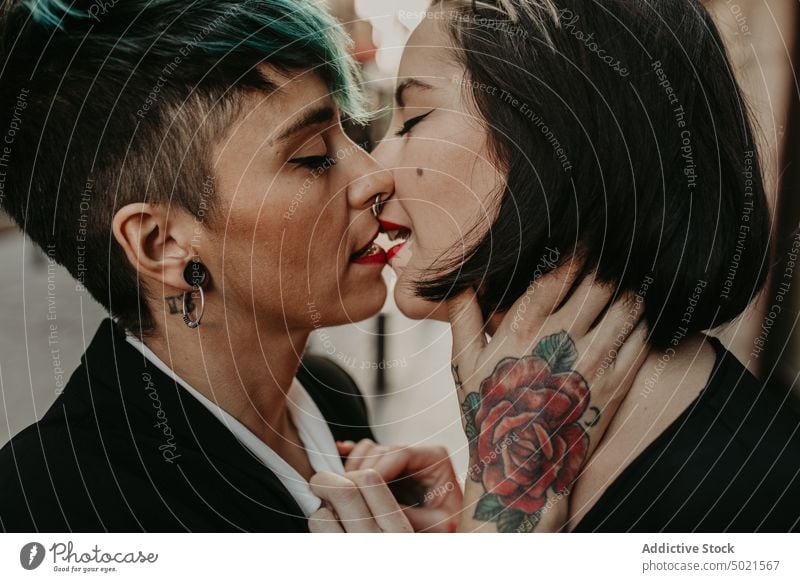 Young stylish ladies kissing on street lesbian couple piercing tattoo love young romantic relationship female adult girlfriend closed eyes lifestyle lovers