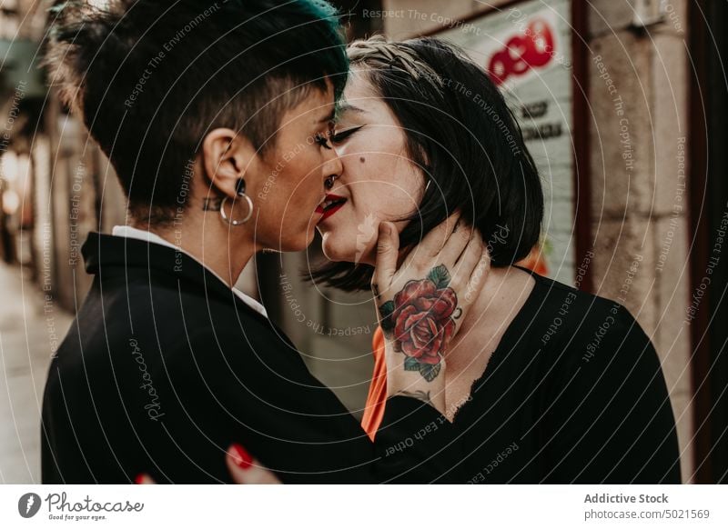 Young stylish ladies kissing on street lesbian couple piercing tattoo love young romantic relationship female adult girlfriend closed eyes lifestyle lovers