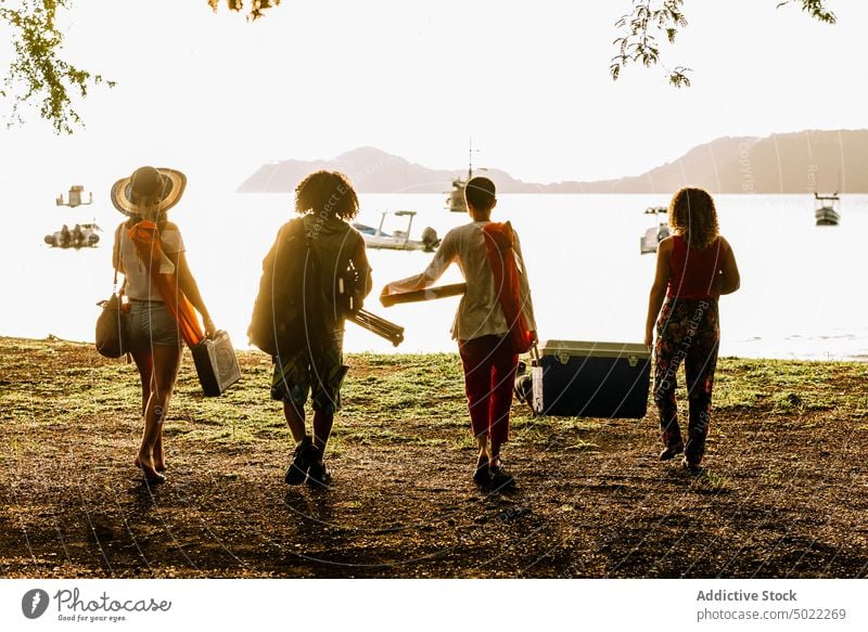 Group of friends gathering for picnic on beach group summer together hangout party friendship lifestyle vacation holiday young weekend shore seaside recreation