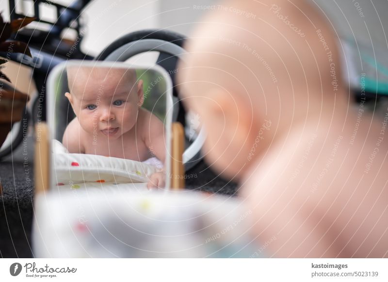 Beautiful shot of a cute baby boy looking at his reflection in the mirror. child portrait play infant childhood beautiful adorable emotion smile happy innocent