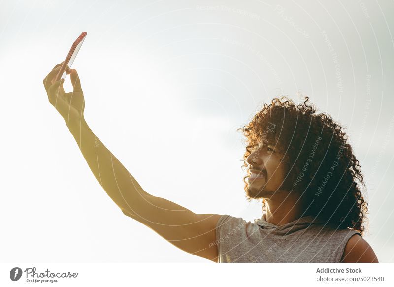 Happy man taking selfie on beach happy summer smartphone cheerful smile vacation carefree colorful male self portrait young millennial enjoy gadget mobile using