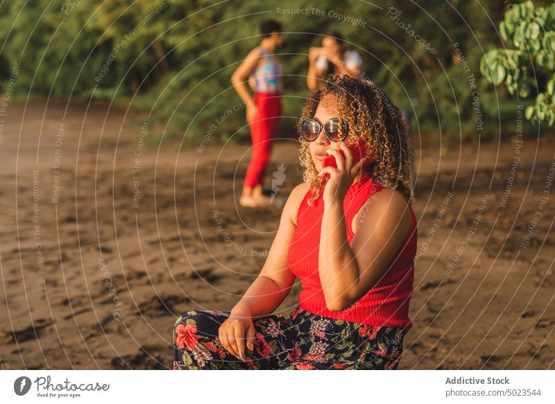 Ethnic woman speaking on smartphone on beach summer talk style sand colorful communicate female ethnic young curly hair sunglasses mobile vacation lifestyle