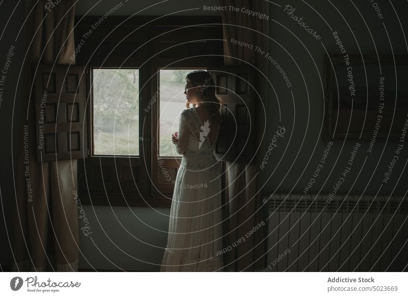 Young woman in dress near window lady wedding headband hair room darkness slim young white looking female passionate romantic waiting obscurity home charming