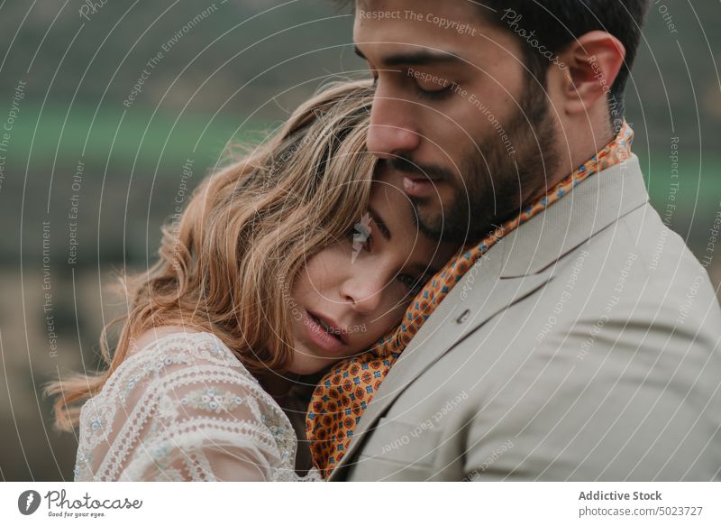 Man hugging with woman on hill and view on valley valentine dress wedding couple lady guy suit embracing picturesque landscape mountain top cloudy young looking